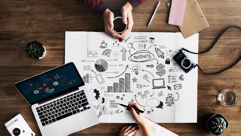 Imagem que ilustra planejamento de negócios com gráficos, anotações e equipamentos de escritório, ideal para estratégias de marketing.