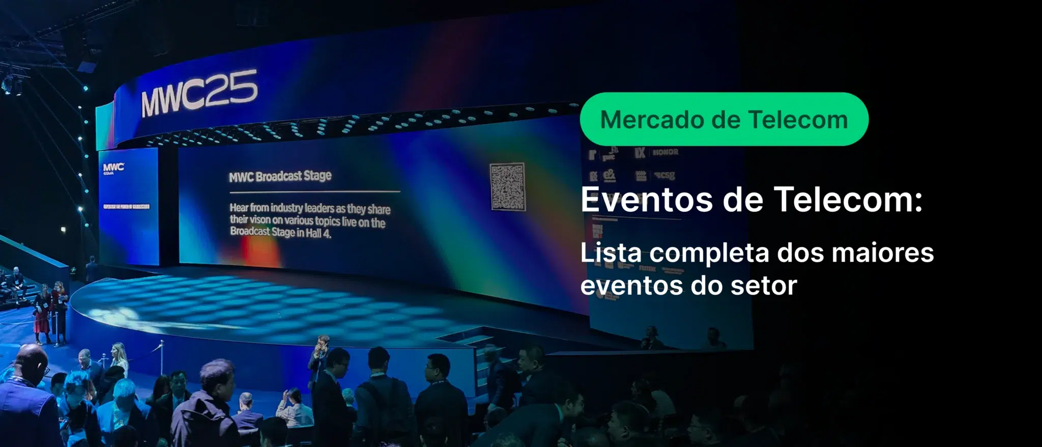 Imagem de um evento de telecomunicações na MWC25, com público assistindo a apresentações na grande tela do palco que exibe informações sobre eventos do setor de telecomunicações.
