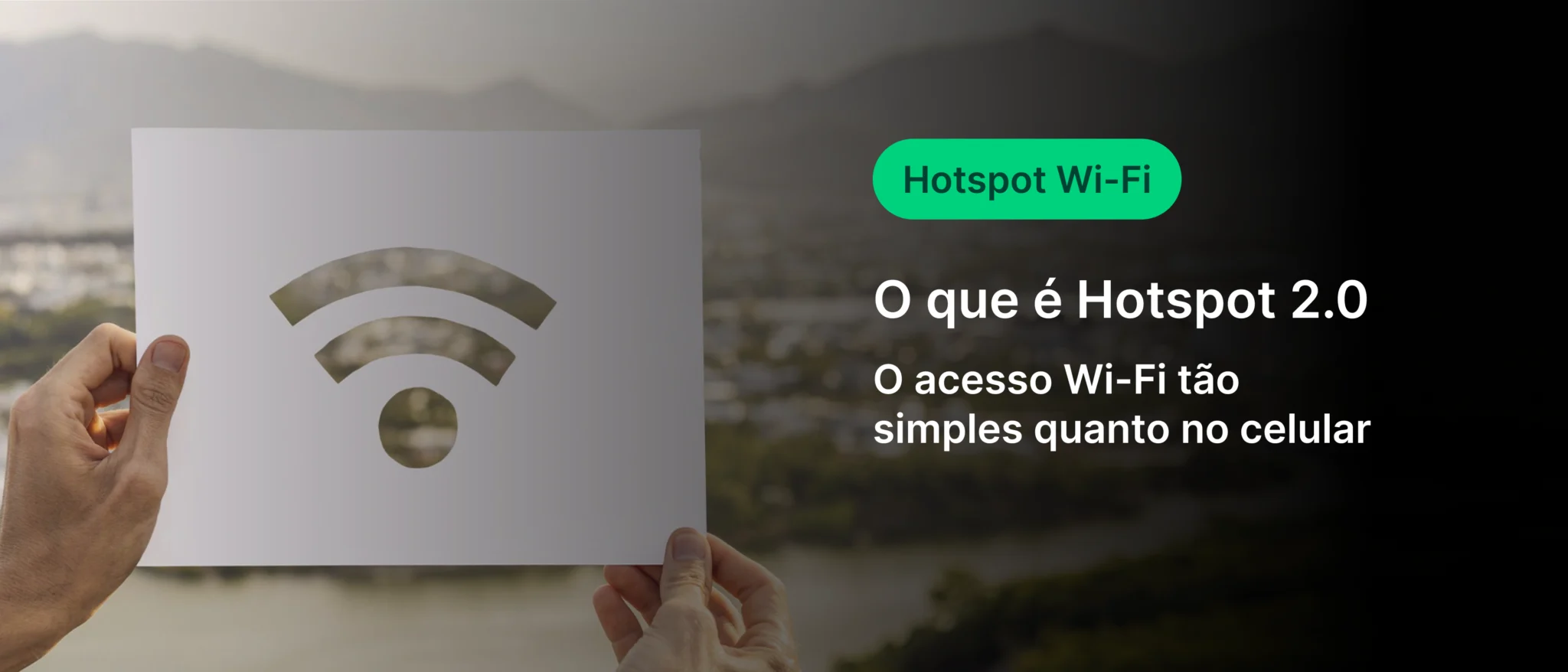 Imagem explicativa sobre Hotspot 2.0 indicando que o acesso Wi-Fi é tão simples quanto no celular, com uma pessoa segurando um cartaz com símbolo de Wi-Fi. Cenário ao ar livre com fundo de montanhas ao entardecer.