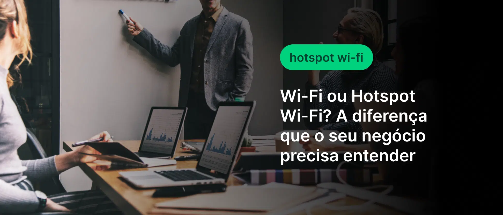 Imagem de pessoas em uma reunião de negócios usando notebooks e celulares em um ambiente corporativo, com texto sobre Wi‑Fi ou Hotspot e a diferença para o seu negócio.