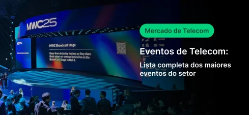 Imagem de um evento de telecomunicações na MWC25, com público assistindo a apresentações na grande tela do palco que exibe informações sobre eventos do setor de telecomunicações.