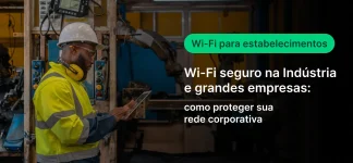Trabalhador da indústria usando capacete e uniforme refletivo em uma oficina, enquanto aparece o texto “Wi‑Fi para indústrias” e “Wi‑Fi seguro na indústria e grandes empresas: como proteger sua rede corporativa”.