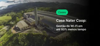 Imagem aérea da Case Nater Coop, uma fábrica inovadora que utiliza tecnologia de gestão de Wi-Fi para reduzir o consumo de energia em até 80%, localizada em uma área verde com montanhas ao fundo.