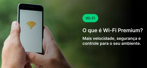 Pessoa segurando um smartphone com um símbolo de Wi-Fi na tela, ao fundo um ambiente ao ar livre. Texto na imagem explica os benefícios do Wi-Fi Premium, como maior velocidade, segurança e controle do ambiente.